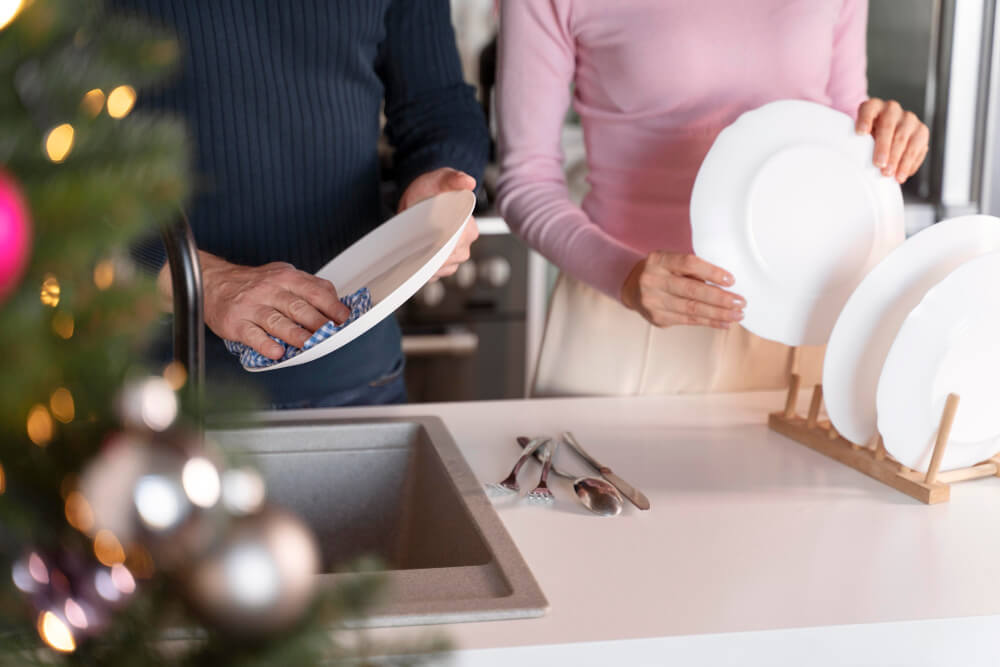 Man and woman washing the dishes together on christmas
