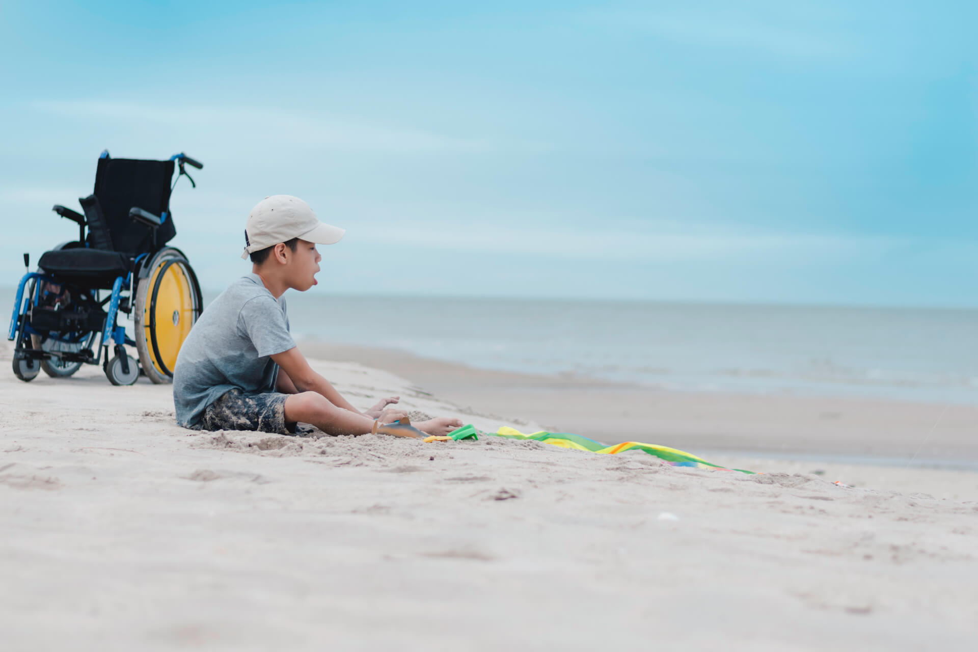 man-sitting-shore-beach-against-sky